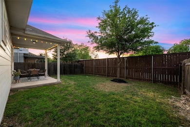 Yard at dusk featuring a fenced backyard and a pa