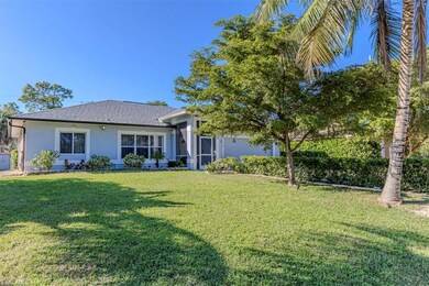 View of front facade featuring a front lawn, stucco siding, and a shingled roof