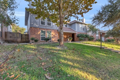 Traditional home with brick siding, a chimney, and a gate