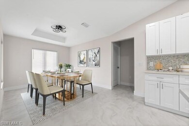 Dining space with a tray ceiling and baseboards