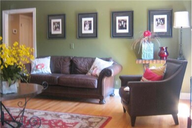 Formal living room has decorator color and beautiful hardwoods.