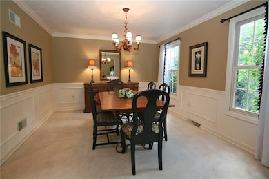 The dining room features crown molding. chair rail