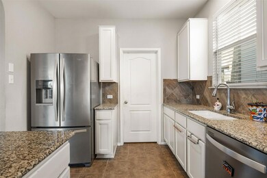 Kitchen with light stone counters, a sink, white 