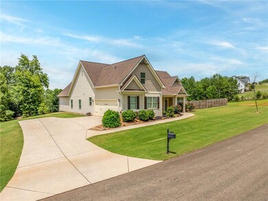 Craftsman inspired home featuring concrete driveway, a front yard, a garage, and roof with shingles