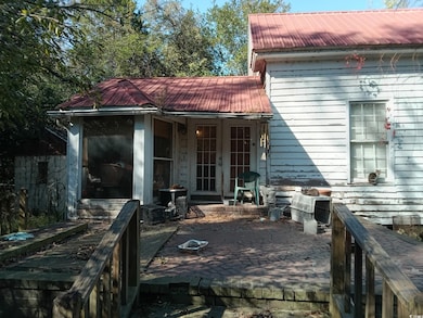 Back of property with a metal roof and a patio