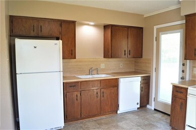 Kitchen featuring white appliances, light counter