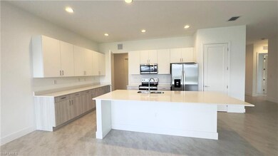 Kitchen with stainless steel appliances, white cabinetry, recessed lighting, a center island with sink, and modern cabinets