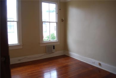 Large light filled bedroom has wood floors, high c