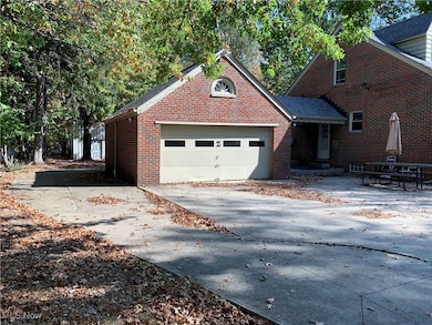 View of front of house with driveway, brick siding, and a garage