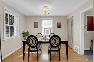 Dining room featuring light wood finished floors and a chandelier
