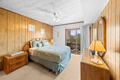 Bedroom featuring wooden walls, access to exterior