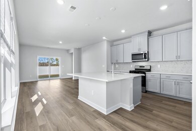 Kitchen with gray cabinetry, sink, an island with 