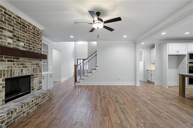 Unfurnished living room with recessed lighting, dark wood finished floors, a fireplace, ceiling fan, and stairway