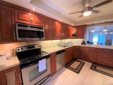 Roomy kitchen with wood cabinets, granite countertops and stainless-steel appliances.