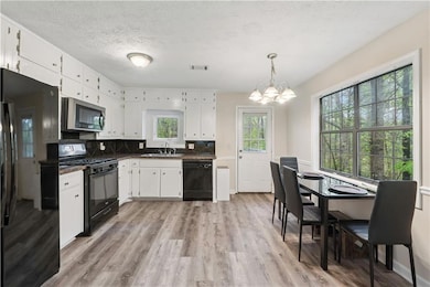 Kitchen with light wood-type flooring, visible ven