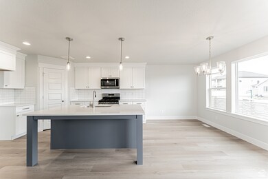 Kitchen with white cabinetry, light countertops, backsplash, a sink, and appliances with stainless steel finishes