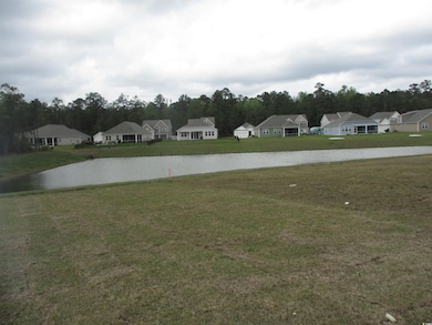 View of grassy yard with a residential view and a water view