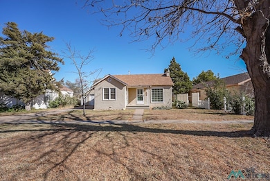 Bungalow with stucco siding, a chimney, and a shingled roof