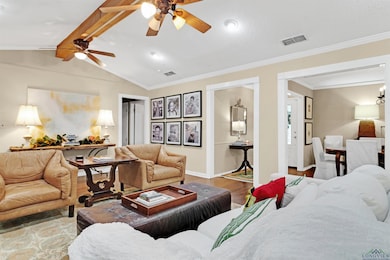 Living room with lofted ceiling with beams, crown molding, and hardwood / wood-style floors