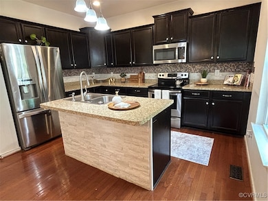 Kitchen featuring fridge, range, a sink, and dark