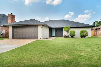 View of front of house with brick siding, a garage, a shingled roof, a front lawn, and driveway