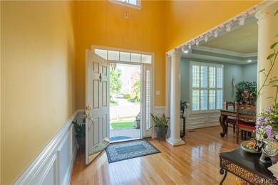 Entryway with light hardwood / wood-style flooring, decorative columns, and a wealth of natural light