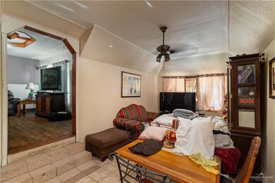 Tiled living room with ceiling fan, a textured ceiling, and vaulted ceiling