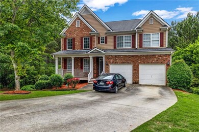 View of front facade with covered porch, concrete driveway, an attached garage, and brick siding