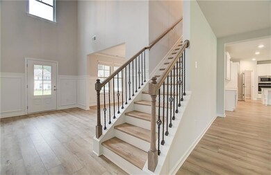 Entrance foyer featuring light hardwood / wood-style floors and a towering ceiling