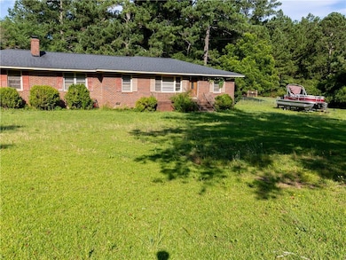 Ranch-style house featuring a front lawn, brick siding, a chimney, and crawl space