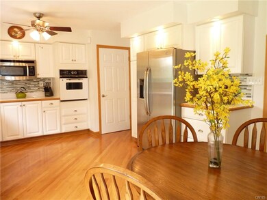 The spacious eat-in kitchen features crisp white c