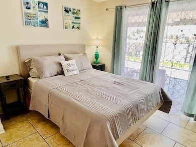 Bedroom with access to outside, light tile patterned floors, and multiple windows