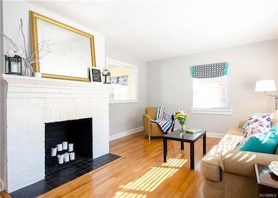 Beautiful brick wood burning fireplace with a great view of the large window opening into the kitchen.