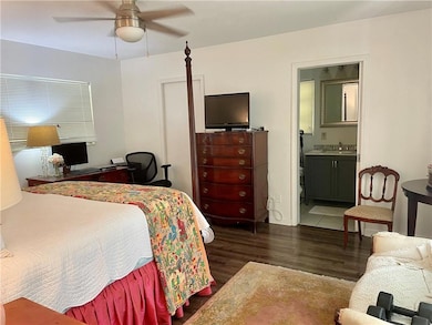 Bedroom with ceiling fan, dark hardwood / wood-sty