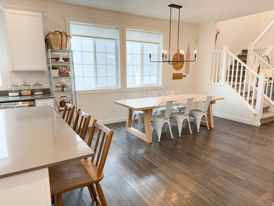 Dining space featuring dark wood-style floors, stairs, and a chandelier