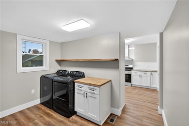 Laundry room with light wood-style flooring and washing machine and dryer