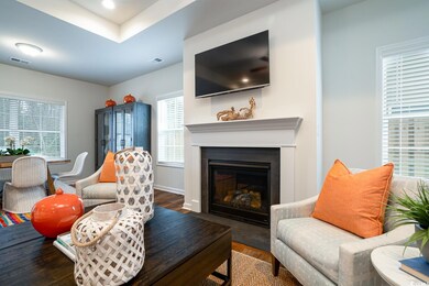Living room featuring visible vents, a fireplace w