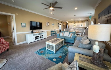 Living room featuring ceiling fan, crown molding, 