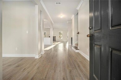 Entrance foyer featuring ornamental molding, light wood-style floors, and stairway