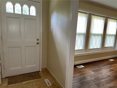 Entryway with baseboards and light wood finished f