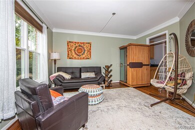 Foyer view into the living room with crown moulding, transom windows, hardwood floor and view into additional room 1 (Butler's Pantry)