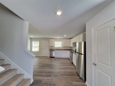 Kitchen with white cabinets, stainless steel appliances, sink, and dark hardwood / wood-style flooring