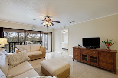 Living room featuring crown molding, light tile pa