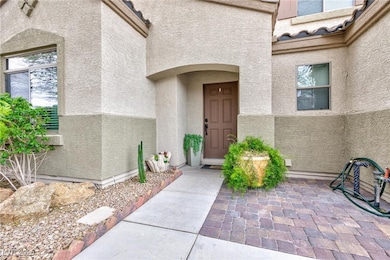View of exterior entry featuring a patio and stucc