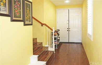 Formal foyer entry with hardwood flooring and stai