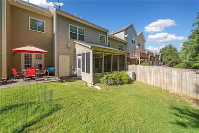 Back of property with a sunroom, a patio area, and cooling unit