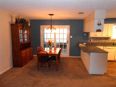 Dining space with a notable chandelier, a textured