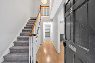 Foyer with light wood-style floors, stairway, and baseboards