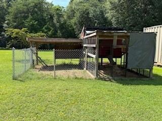 View of yard with exterior structure, an outbuilding, and a view of trees
