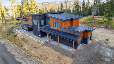 Rear view of house featuring a view of trees and a metal roof